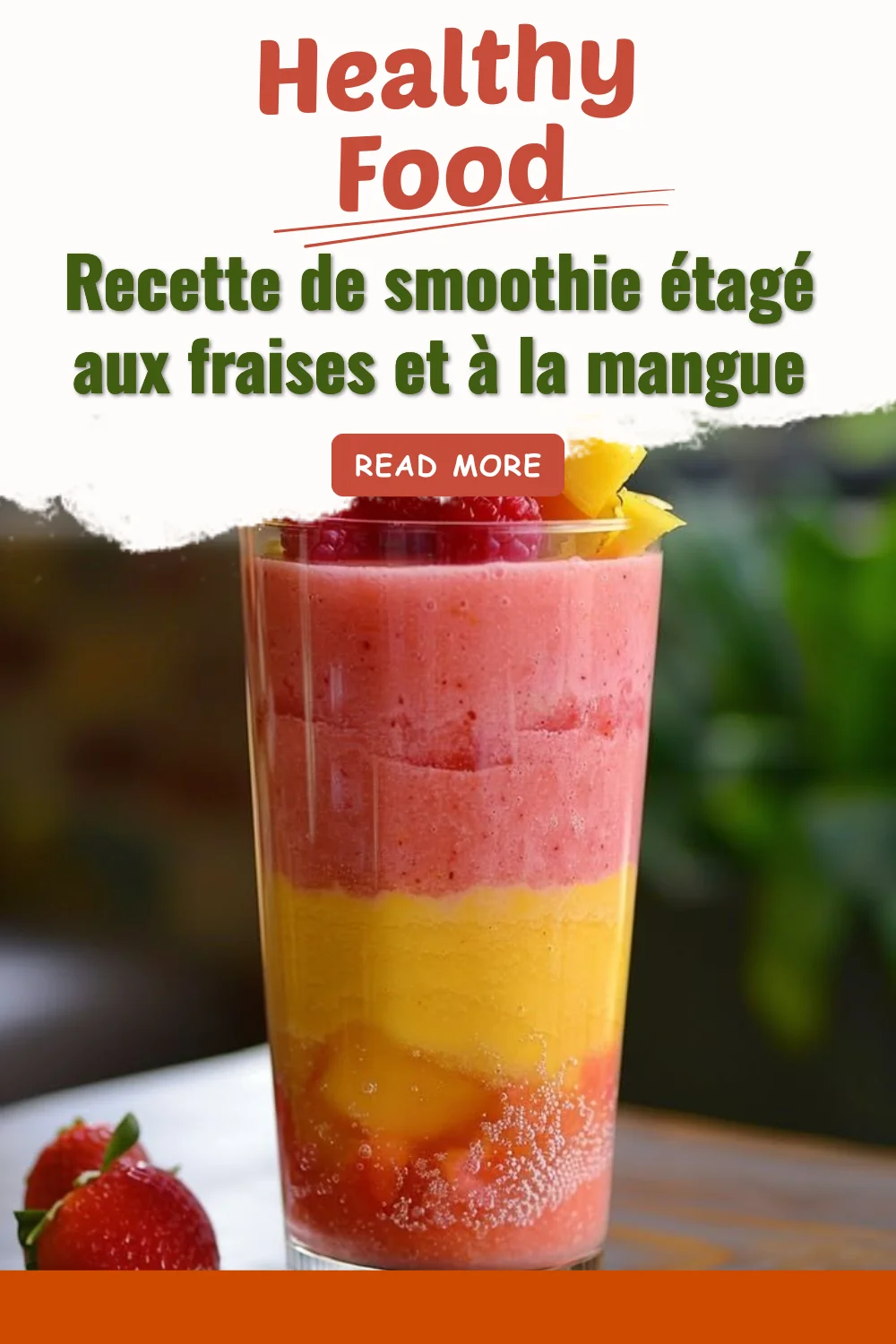 Smoothie étagé aux fraises et à la mangue dans un verre transparent