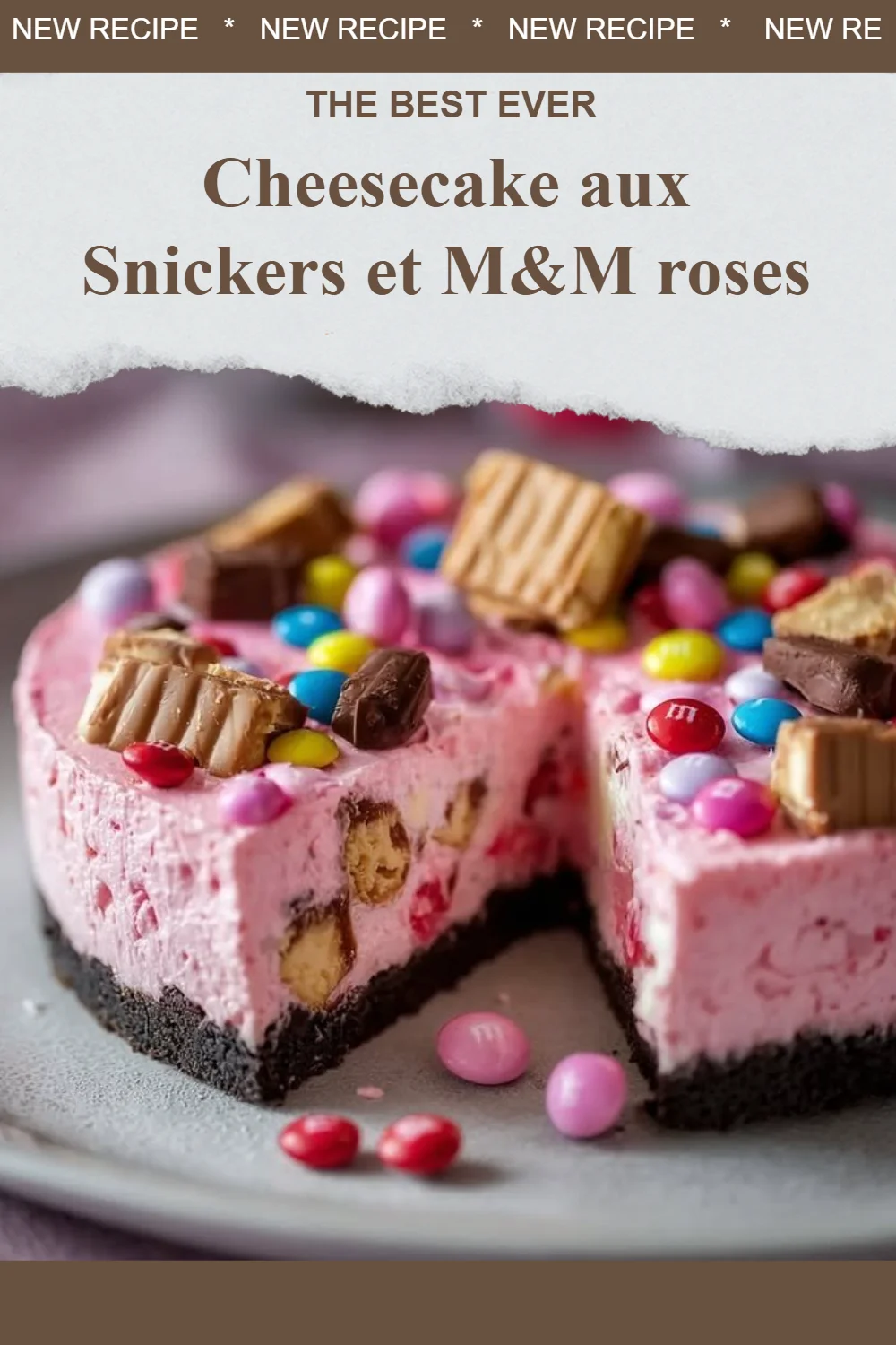 Cheesecake aux Snickers garni de M&M roses, un dessert savoureux.